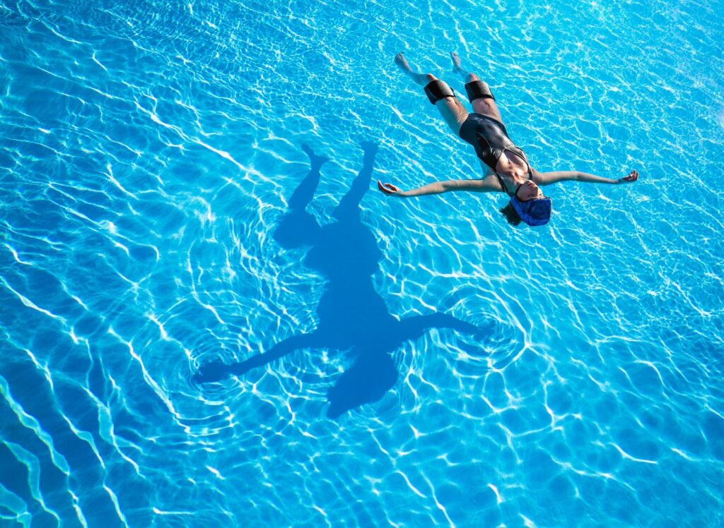 Manneskja flýtur á bláu, tæru vatni