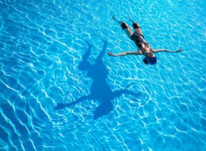 Manneskja flýtur á bláu, tæru vatni